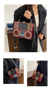 Detail of vintage radio acrylic crossbody bag in burgundy with golden accents