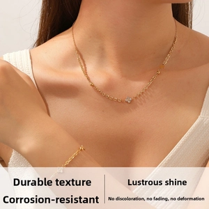 Detail of gold plated stainless steel necklace and bracelet set with diamond flower charms