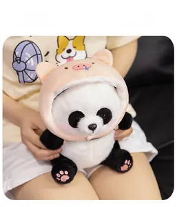 Close-up of soft panda plush wearing a pink pig hoodie with detailed paw embroidery