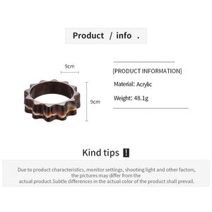 Detailed view of wide amber acrylic flower bangle with gear edges and 9cm size label
