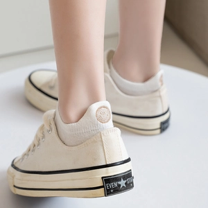 Beige platform canvas shoes with low cut socks featuring a brown smiley face embroidery