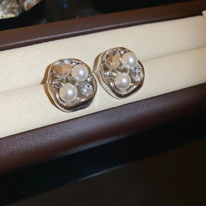 Detail of silver irregular earring featuring three pearls and sparkling clear gemstones