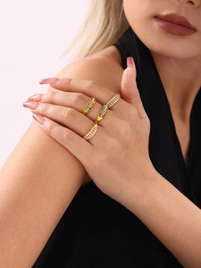 Close-up of gold adjustable rings with colorful zircons and pearls worn by a model