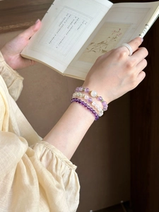 Detail showing natural amethyst and green jade beaded bracelets with a white jade ring