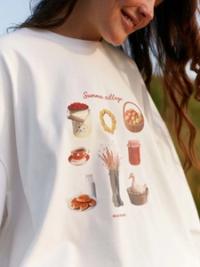 Detail of white sweatshirt with Summer Village artistic print and cozy lifestyle graphics