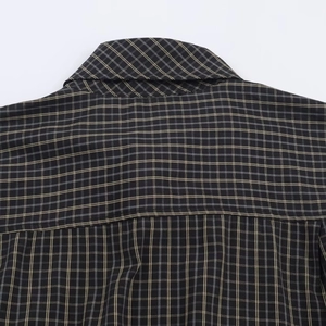 Detail of high-density plaid fabric texture and collar stitching on long sleeve shirt