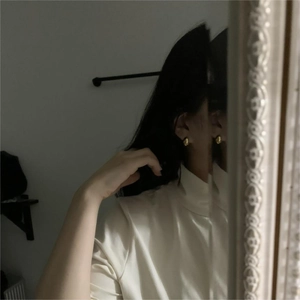 Mirror selfie showing the minimalist golden oval hoop earring for a stylish daily look