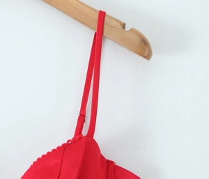 Detail of red silk strap dress featuring thin adjustable buckles and lace trim
