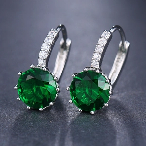 Detail showing round-cut green gems set in silver hoop earrings with diamond accents