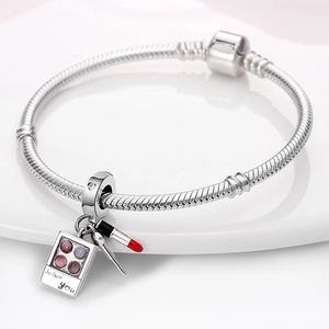 Silver charm bracelet with 925 stamp featuring lipstick and eyeshadow makeup pendants