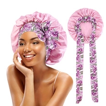 Detailed close-up of pink satin hair bonnet with a floral adjustable ribbon tie
