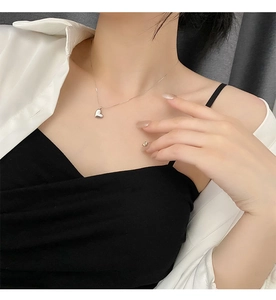 Polished silver heart pendant necklace displayed on model for minimalist style