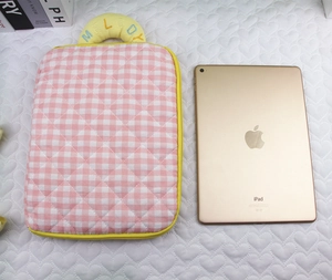 Detail of pink plaid quilted iPad sleeve with yellow embroidered 'MELODY' handle