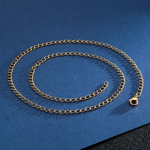 Detail of a 4mm gold stainless steel curb chain with lobster clasp on a dark background