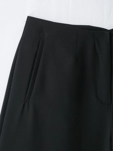 Gros plan d'un pantalon noir taille haute montrant la texture du tissu et les coutures