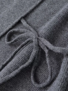 Detail of dark grey ribbed knit fabric texture with matching soft knitted tie closure