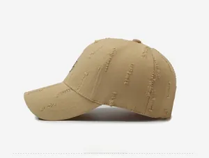 Detailed side view of khaki baseball cap featuring distressed holes and embroidered logo