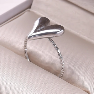 Macro shot of polished heart-shaped ring with textured band in an elegant jewelry box
