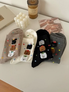Dettaglio di quattro paia di calze in cotone con ricami di animali e pois colorati
