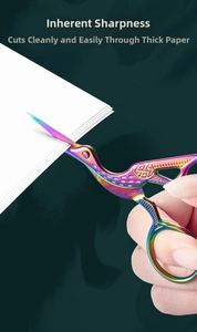 Dettaglio di forbici vintage a forma di gru arcobaleno che tagliano il cartone