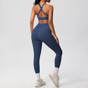 Detalle del sujetador deportivo con espalda cruzada y mallas de yoga en azul oscuro