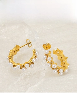 Close-up of gold-plated stainless steel C-shaped earrings with pearls and crystals