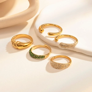 Detailed close-up of a five-piece vintage gold ring set with pearls and emerald zircons