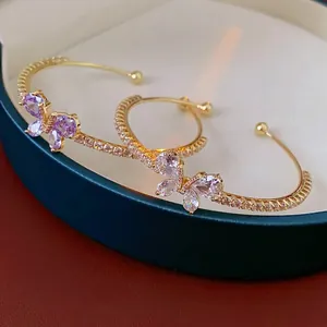 Bracelet jonc papillon doré minimaliste avec zircons violets sur boîte à bijoux