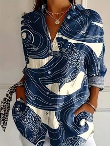 Detail of blue and white long-sleeved shirt featuring large fish and wave print patterns