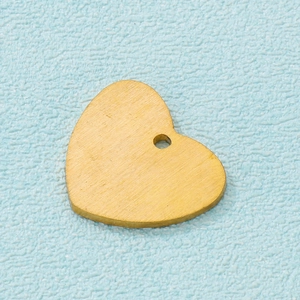 Macro shot of gold-plated matte heart pendant with brushed texture and top hanging hole
