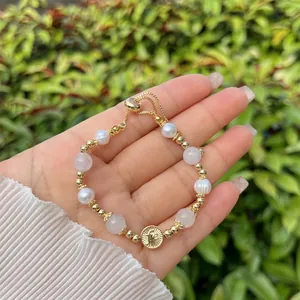 Detail of handmade 18k gold plated bracelet with pearls, pink beads and coin charm
