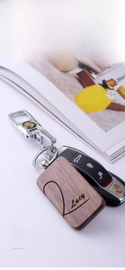 Macro detail of custom wood keychain with Lucy engraving attached to a car key