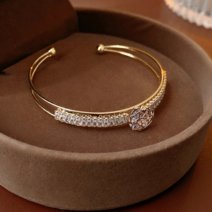 Detailed close-up of a gold rose zircon bangle on a luxury velvet jewelry display