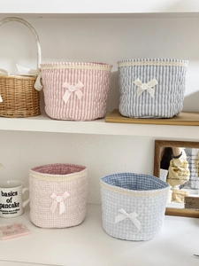 Close-up of quilted cotton storage baskets with lace trim and decorative bows
