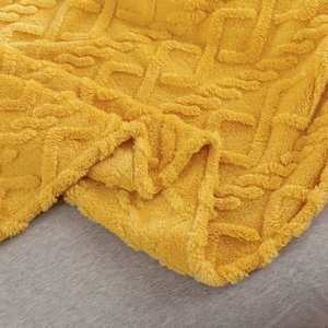 Soft yellow flannel throw blanket with 3D jacquard diamond texture on a bed