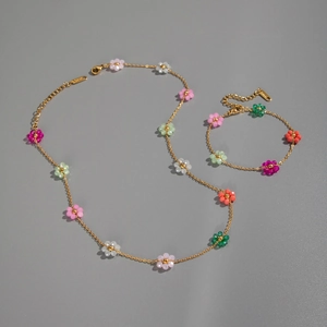 Detailed view of colorful beaded flower necklace and bracelet set with gold chain finish