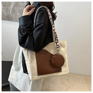 Detail of canvas tote bag with brown leather trim, coin purse and patterned strap