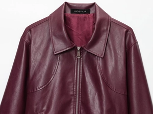 Dettaglio della giacca in pelle bordeaux scuro con colletto e trama della zip metallica