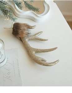 Close-up of champagne gold glitter reindeer antlers with faux fur and golden string