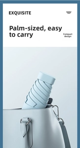 Close-up of mini light blue portable umbrella fitting perfectly inside a small handbag