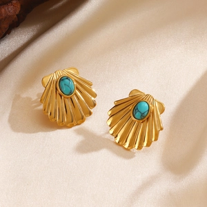 Golden shell earrings with turquoise stones on beige silk background for women