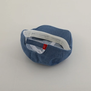 Dettaglio berretto bimbo in denim blu scuro con cinturino regolabile ed etichetta