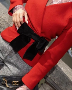 Detail of red blazer with large black velvet bow and gold V-logo chain bag