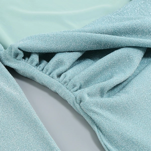 Detail of teal sequin fabric with elegant pleated texture and shimmering glitter finish
