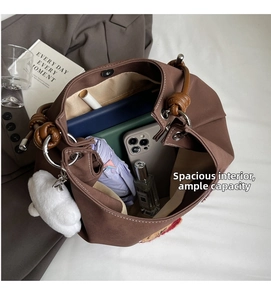 Interno della borsa tote marrone con grande capacità per oggetti e ciondolo di peluche