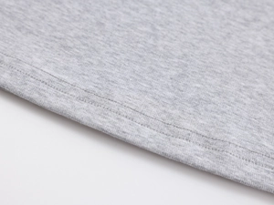 Detailed macro view of gray knitted fabric texture and fine double-needle stitching on the vest
