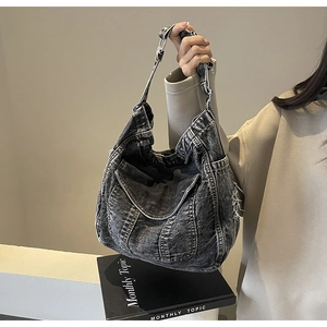 Détail du sac hobo en denim délavé vintage avec bandoulière réglable et boucles métalliques