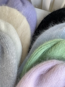 Nahaufnahme bunter Angora-Strickmützen mit weicher Plüschtextur und Details