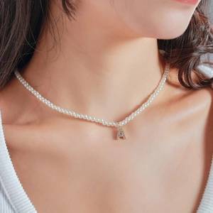 Imitation pearl necklace featuring a gold letter A pendant with sparkling rhinestones