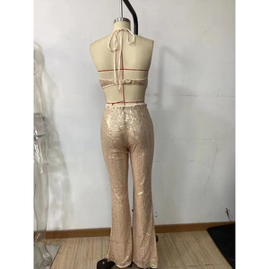 Back view of champagne gold sequin halter top and flared trousers on a mannequin